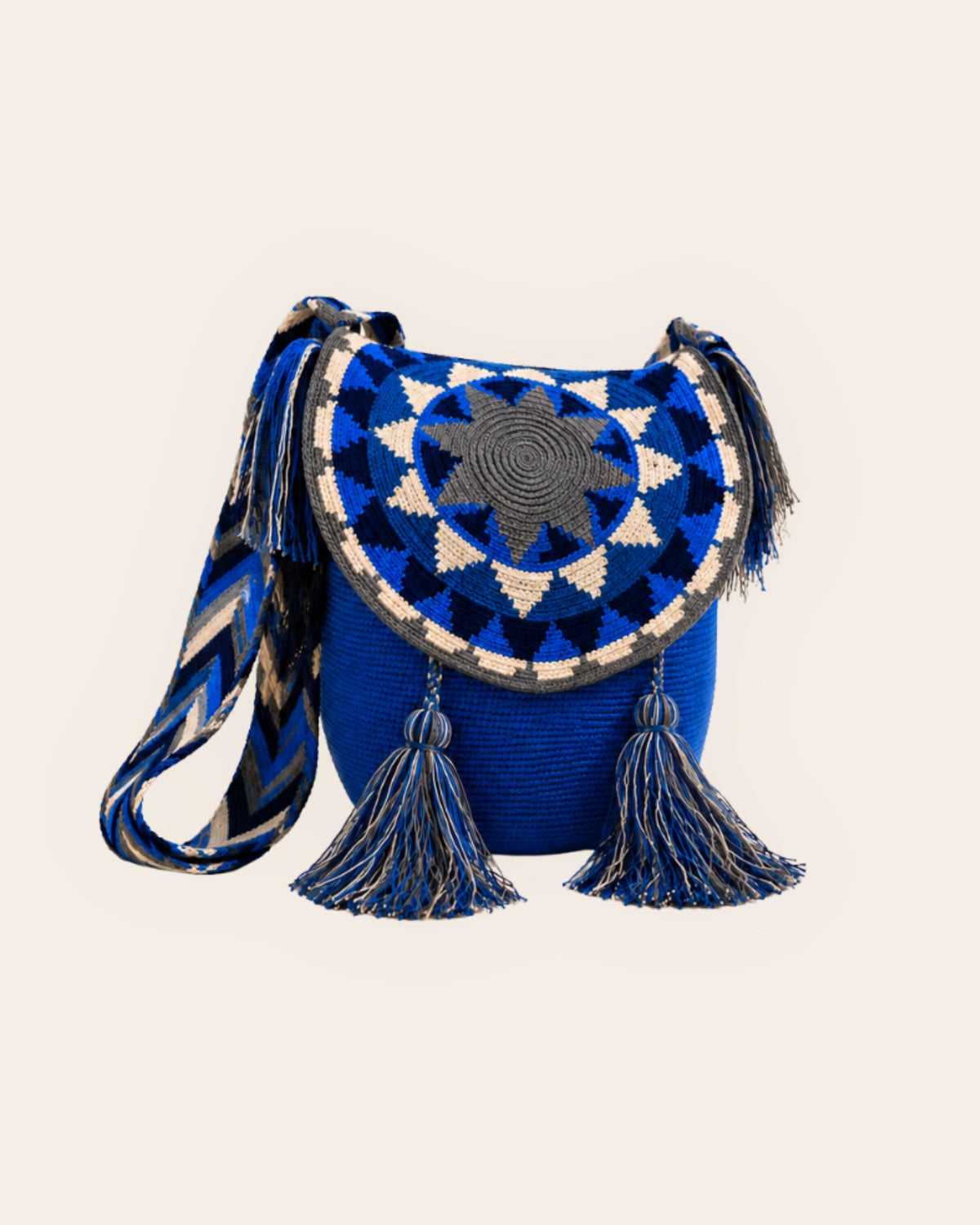 Cobalt blue Wayuu crochet flap bucket bag with geometric circular flap, woven shoulder strap and tassel details.