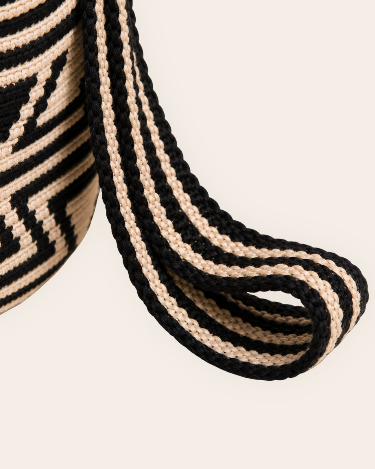 Handwoven sand and black shoulder strap on Wayuu crochet mochila