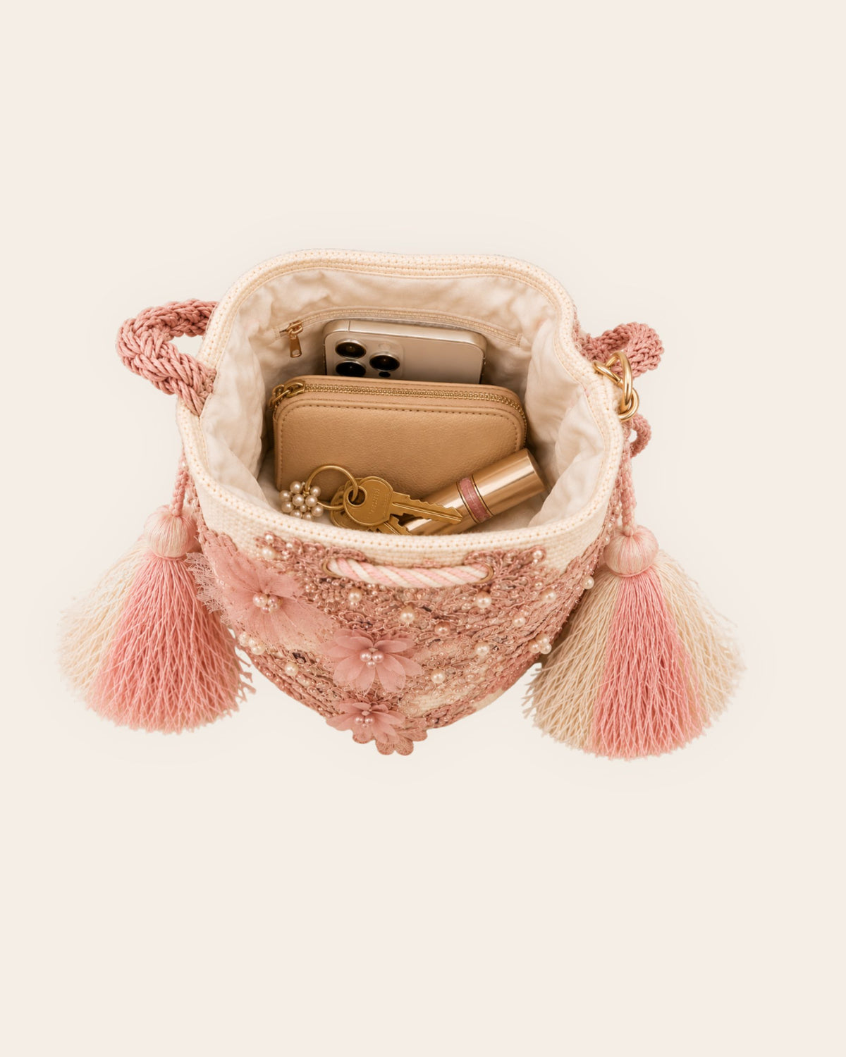 Interior of pink embellished bucket bag showing lining, pocket and space for everyday essentials