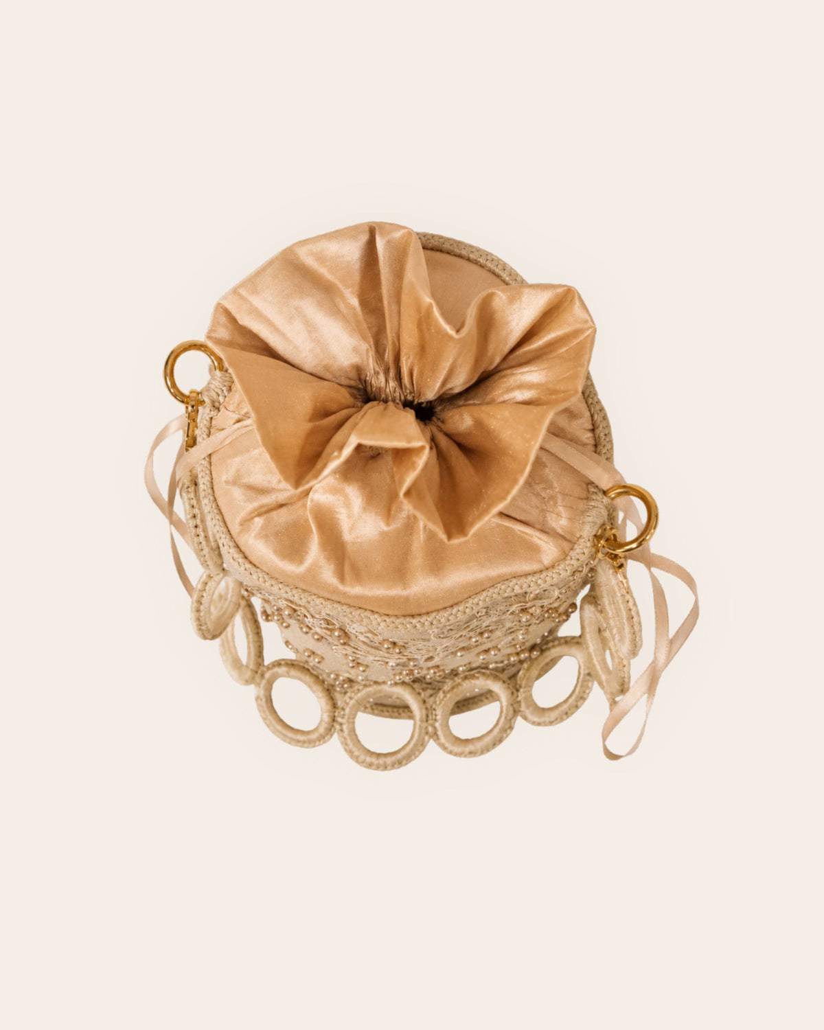 Top view of champagne handmade occasion bag showing fabric drawstring closure and crochet details