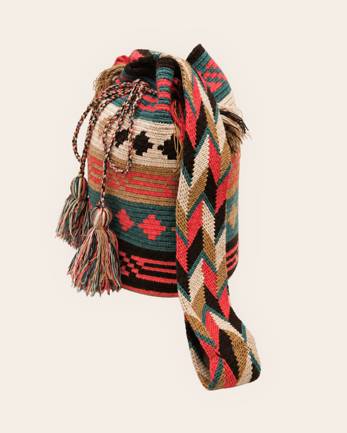 Side view of the Coral Oasis Wayuu crochet Classic Mochila with handwoven strap and tassels