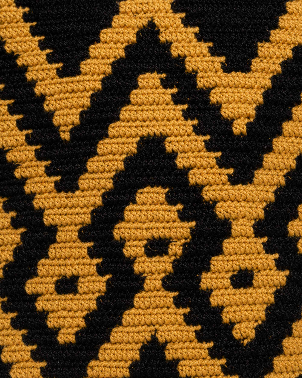 Side profile of Maresa Black & Camel Wayuu Crochet Flap Backpack