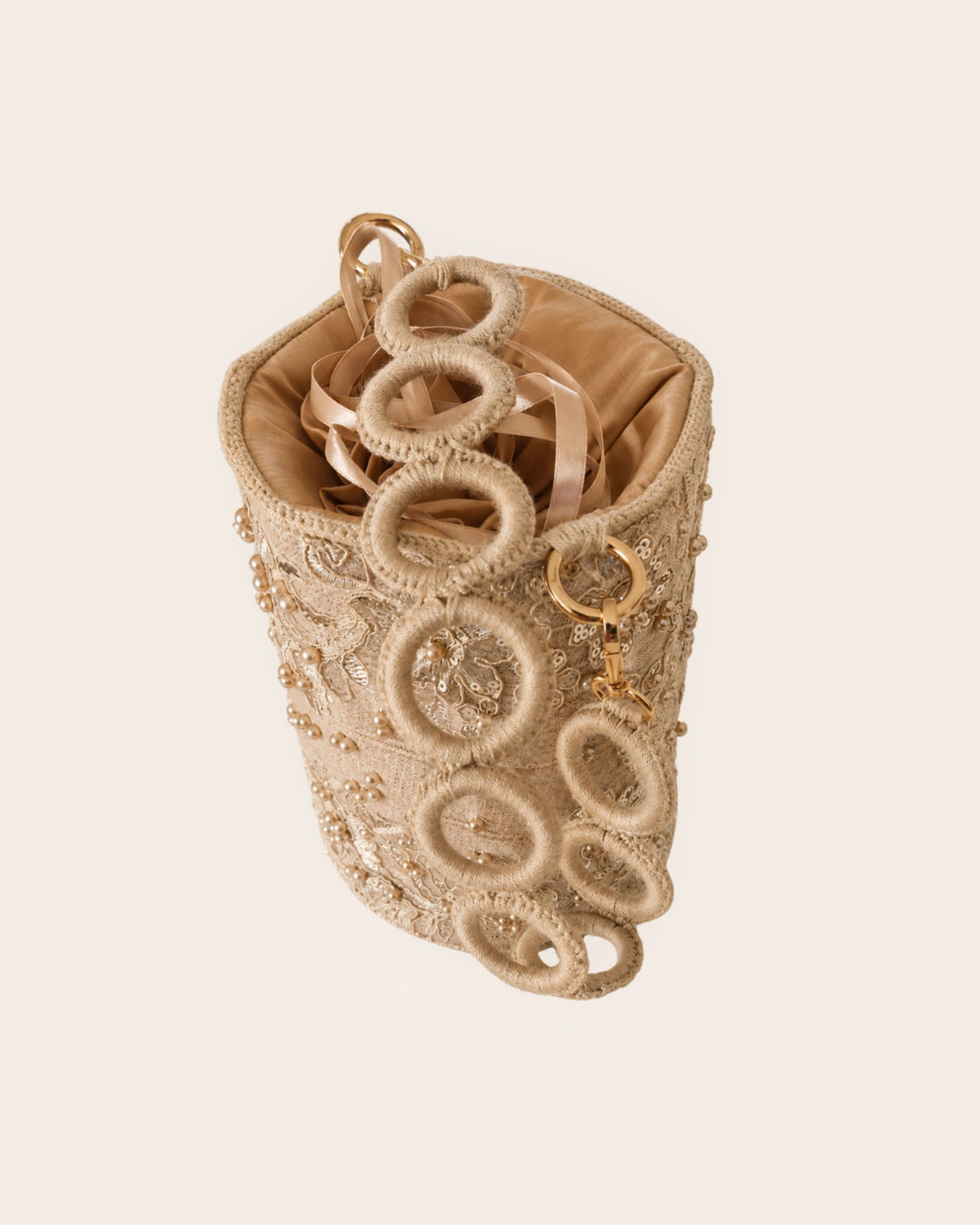 Side view of champagne embellished occasion bag with detachable circular crochet shoulder strap
