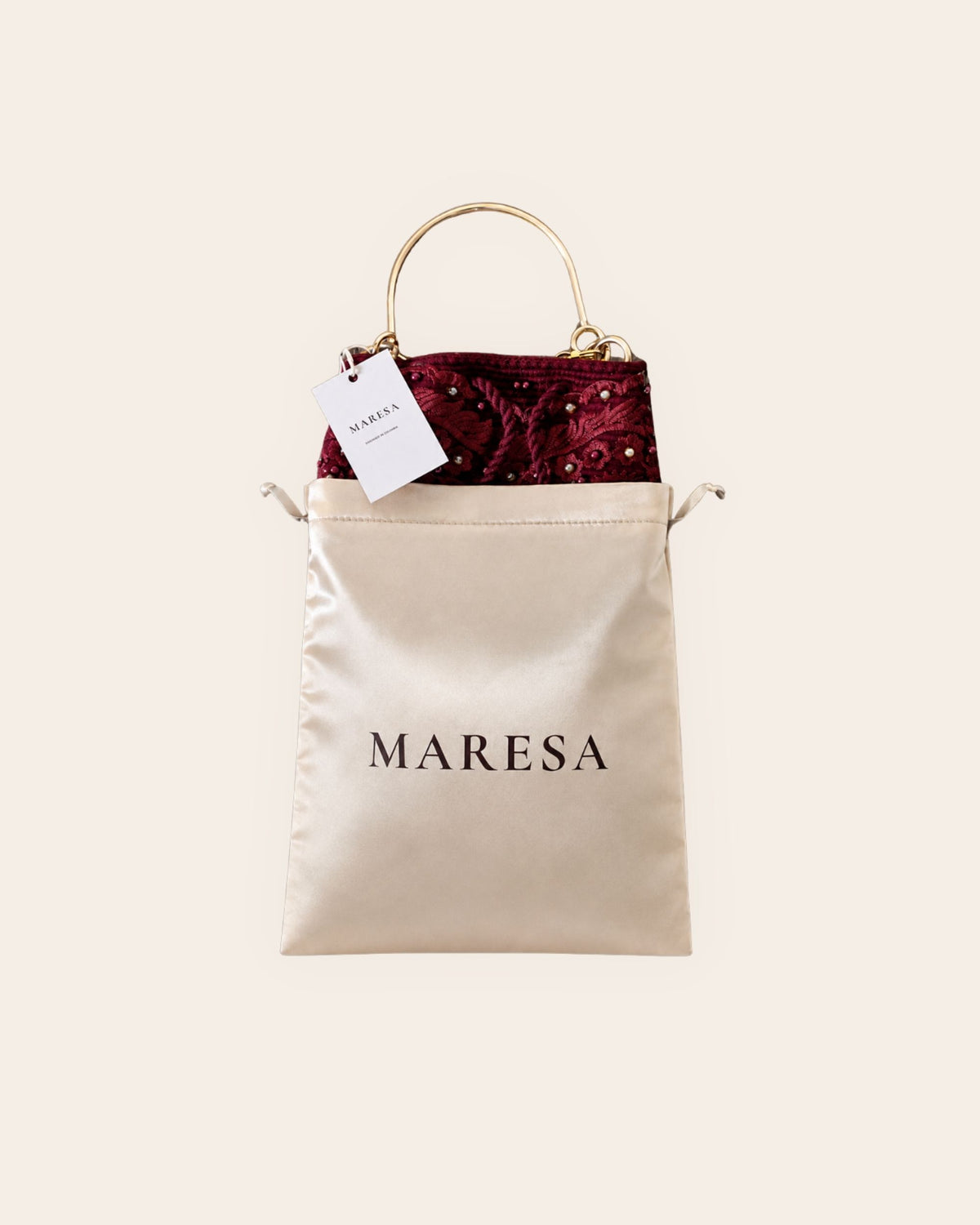 Burgundy Maresa occasion bag presented in its champagne satin branded dust bag