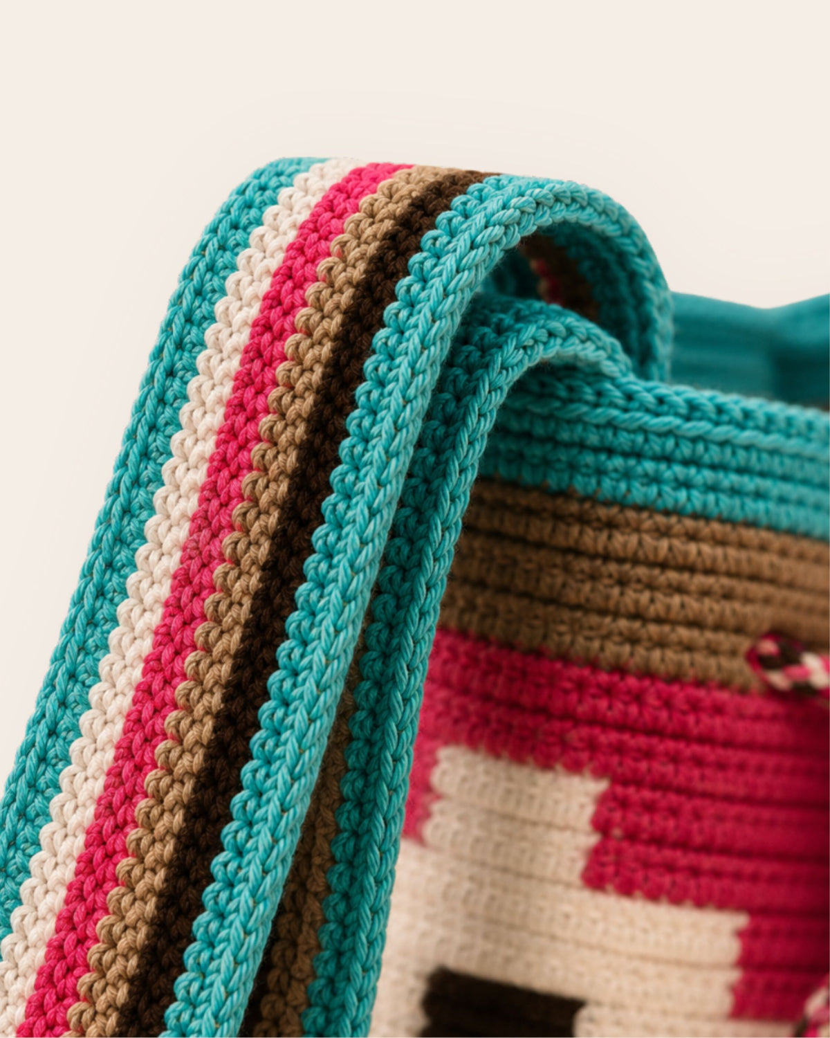 Close-up of the handwoven shoulder strap on the Maresa Turquoise, Fuchsia & Chocolate Wayuu Crochet Mochila.