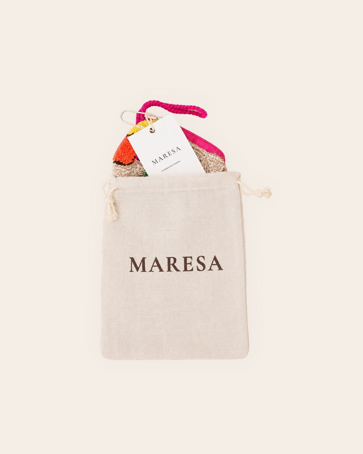 Maresa multicolour textile mini pouch presented with branded cotton dust bag and Maresa hang tag on a beige background