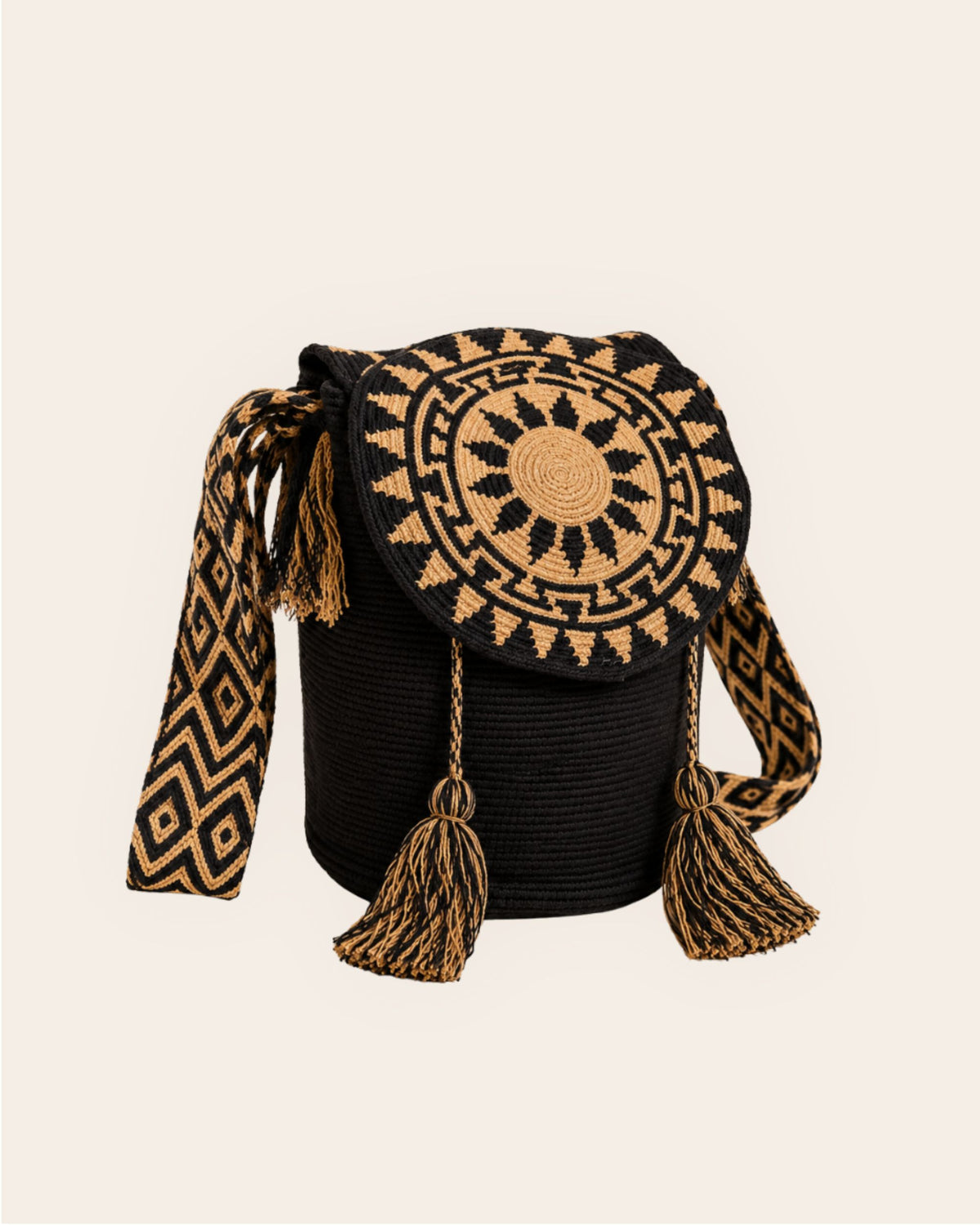 Black and camel Wayuu crochet Flap Bucket Bag with circular geometric flap, woven shoulder strap and tassel details. 
