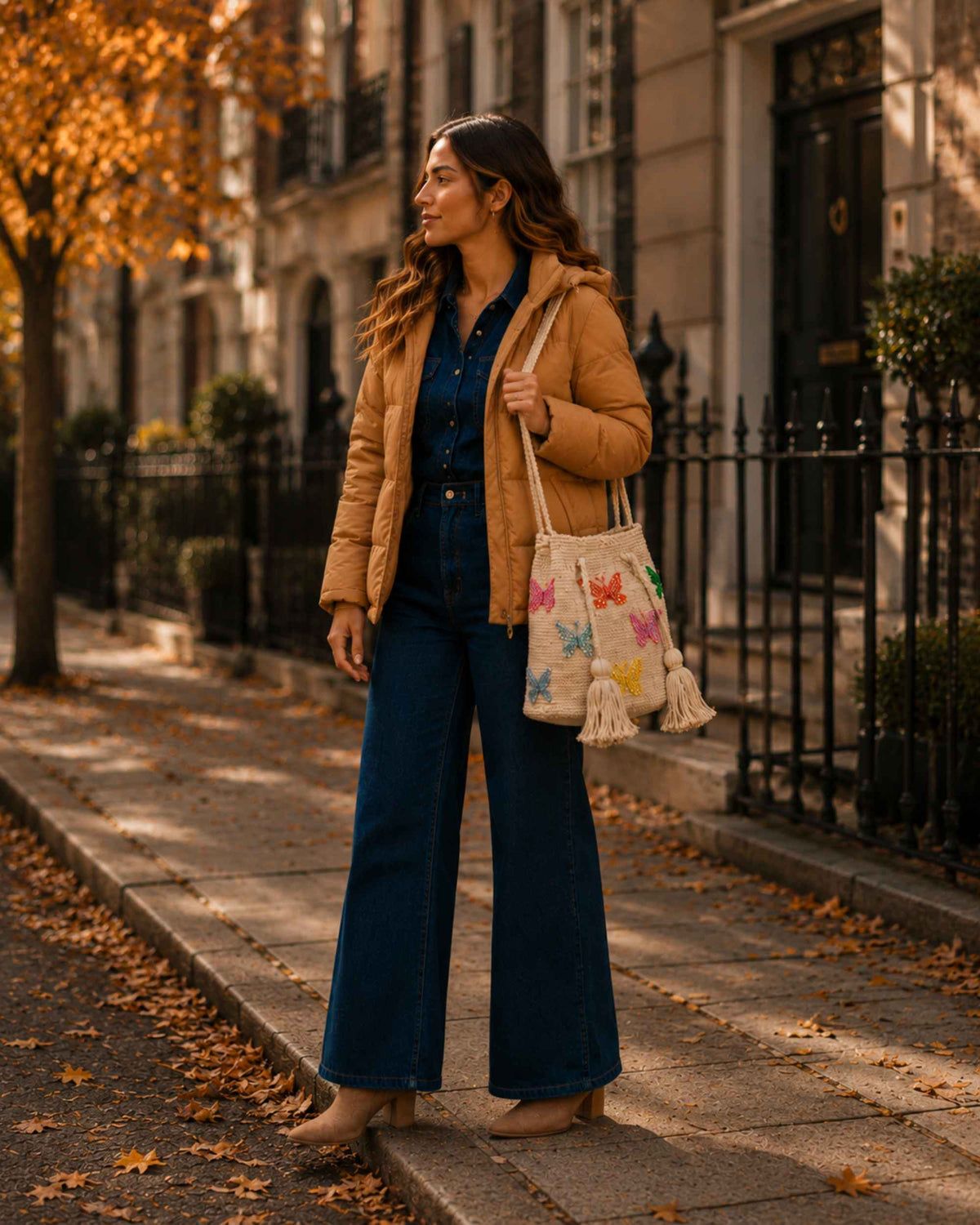 Woman carrying a beige butterfly embellished Wayuu crochet bag with a casual autumn outfit. 