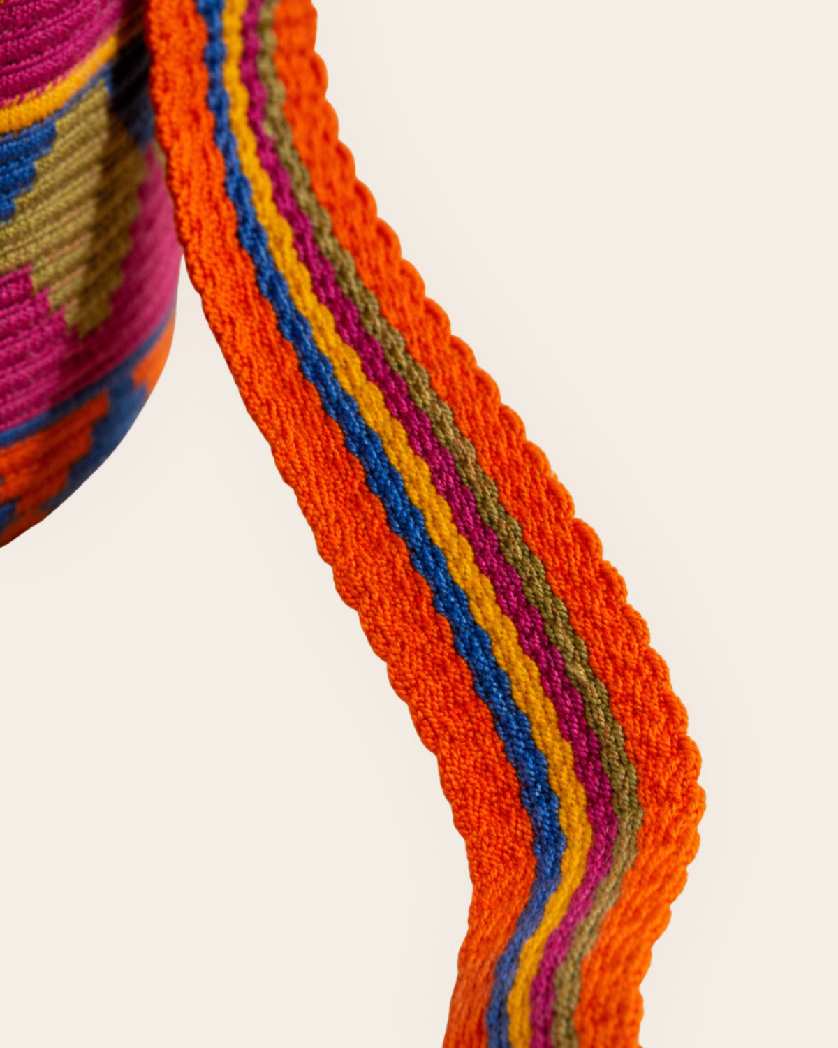 Close-up of the handwoven shoulder strap on the Maresa Orange, Blue & Fuchsia Wayuu Crochet Mochila.