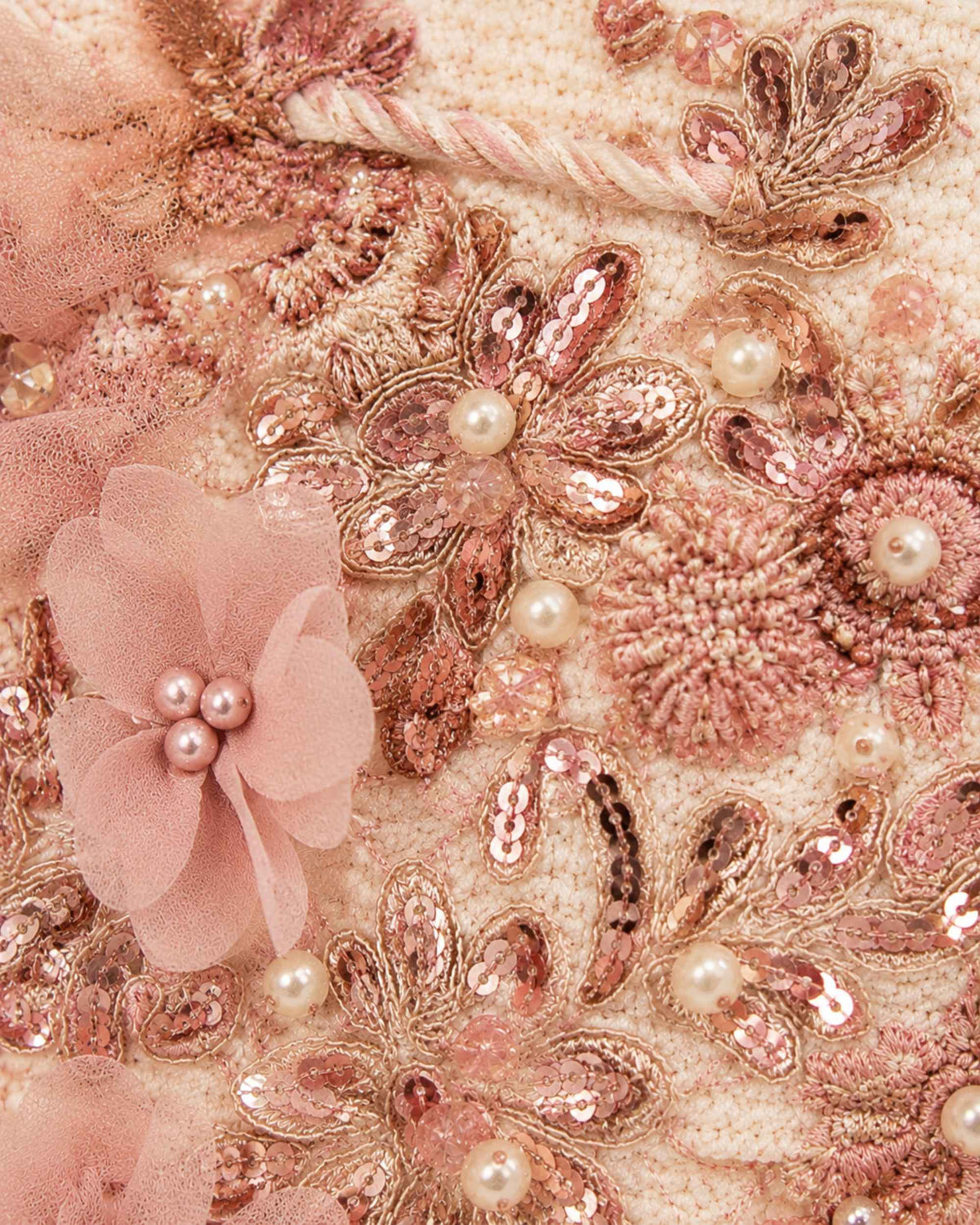 Close-up of pink floral embellishments, pearls, beads and sequins on handcrafted bucket bag 