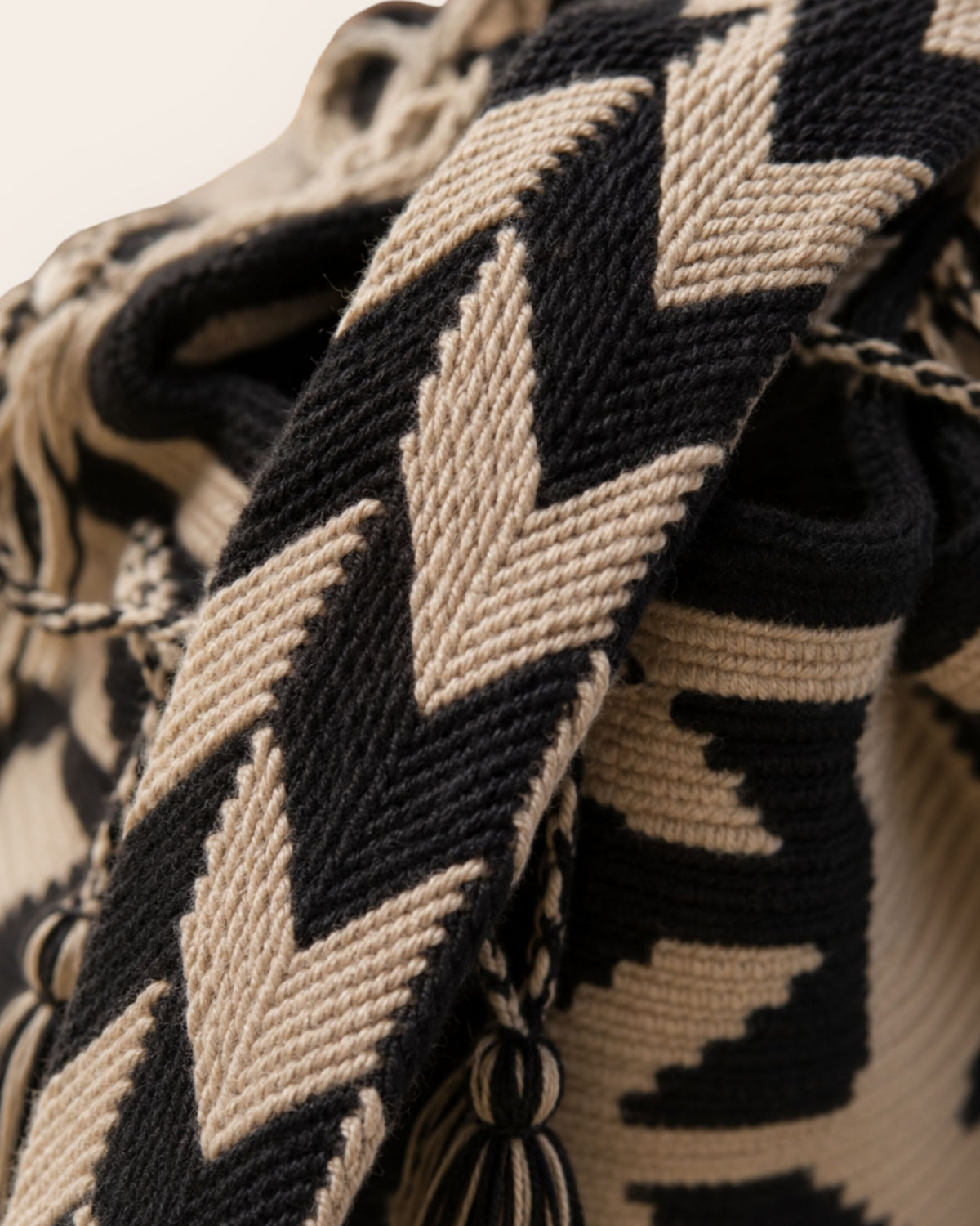 Close-up of the handwoven shoulder strap on the Maresa Sand & Black Wayuu Crochet Classic Mochila 