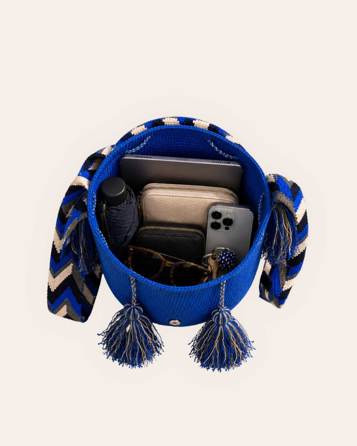 Open cobalt blue Wayuu crochet flap bucket bag showing its spacious interior and everyday essentials. 