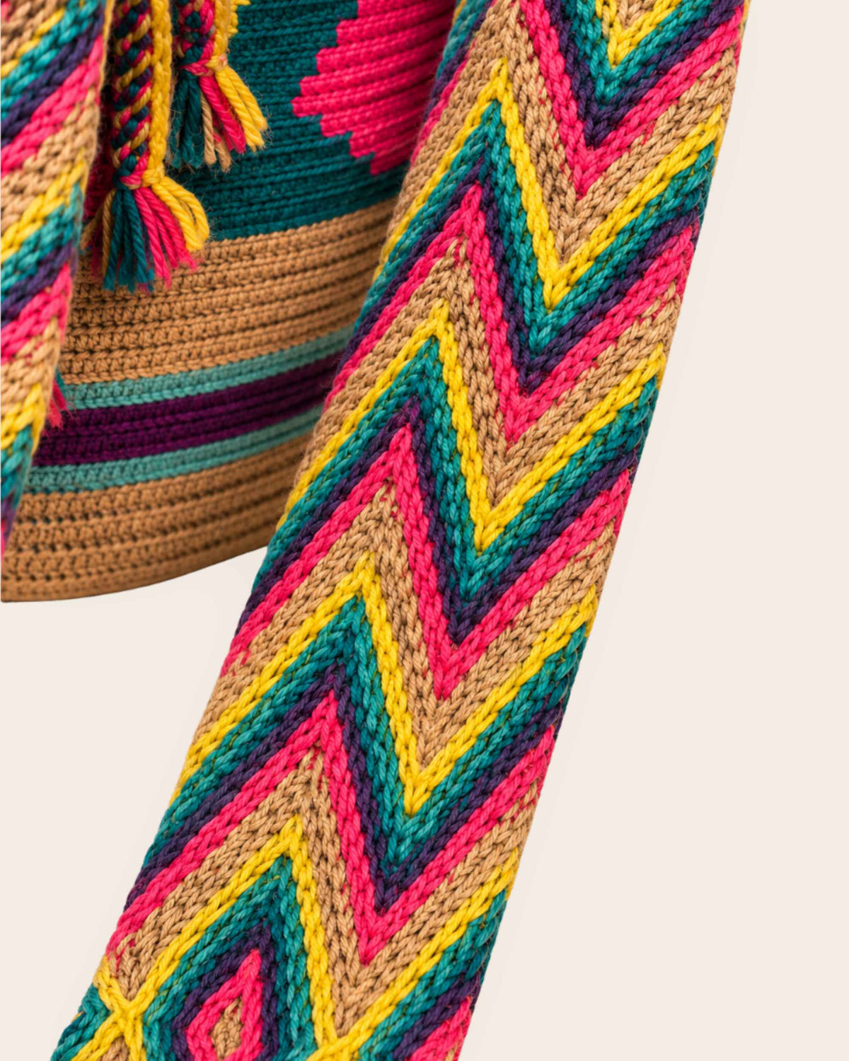 Close-up of handwoven strap on sand multicolour Wayuu crochet classic mochila 