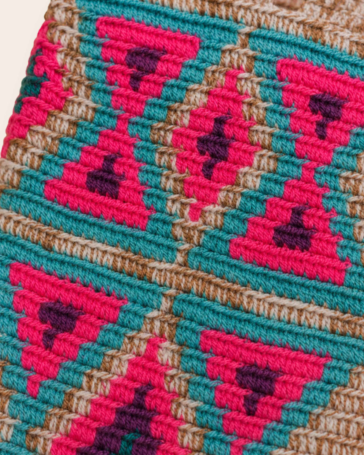 Close-up of the colourful woven textile pattern and handcrafted stitching of the mini bag 