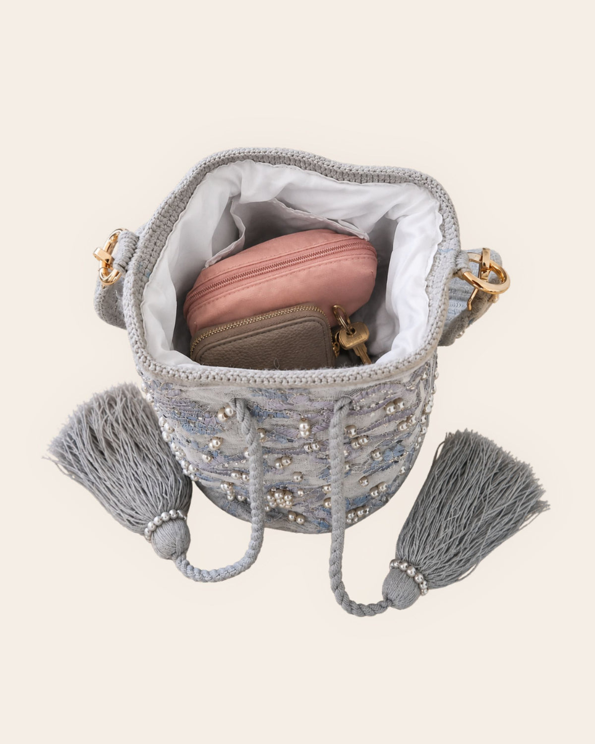 Open pearl grey embellished occasion bag showing lined interior and space for everyday essentials 