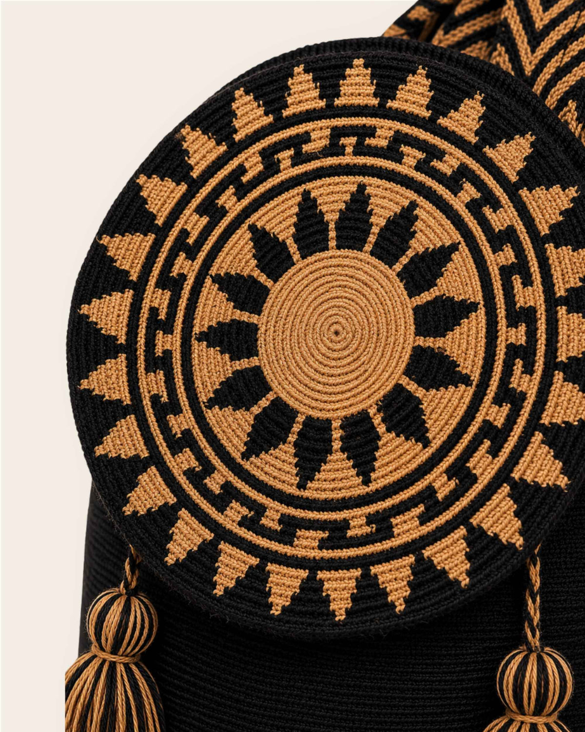 Close-up of the circular black and camel geometric crochet flap on the Wayuu Flap Bucket Bag. 