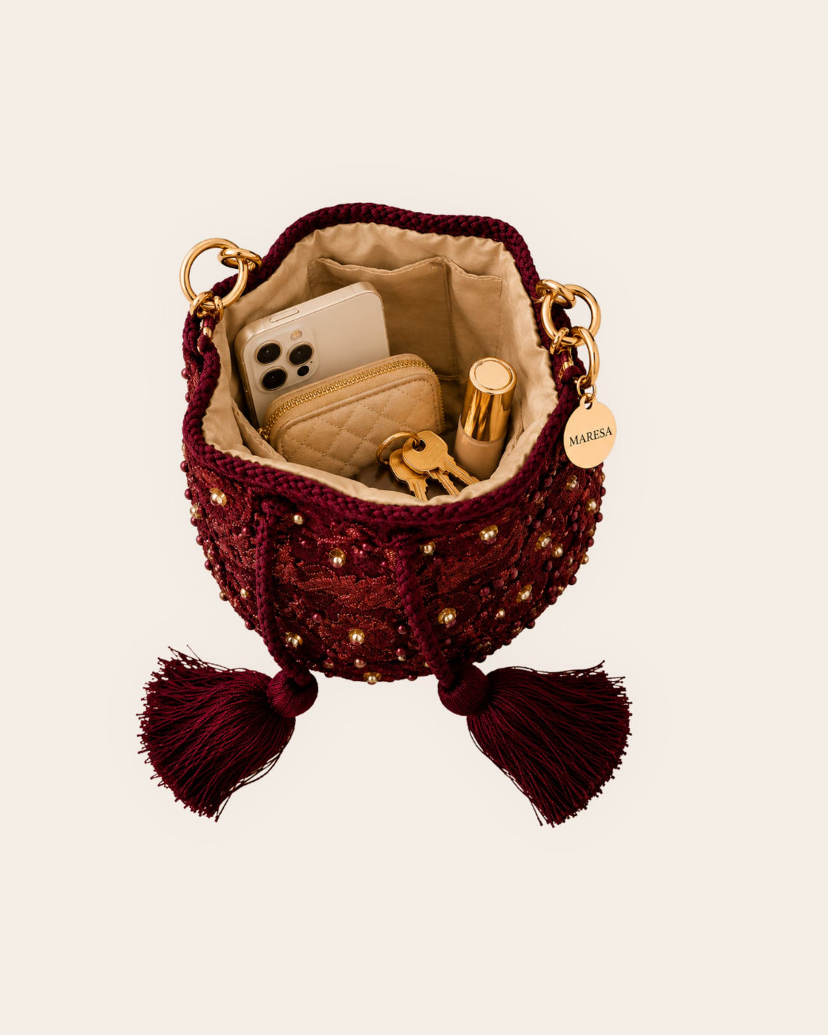 Open burgundy occasion bag with lined interior, slip pocket and space for phone, wallet, keys and cosmetics 