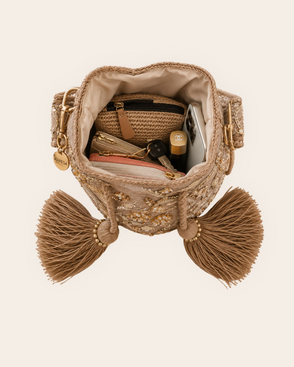 Open champagne gold occasion bag showing lined interior with phone, keys, cosmetics and small accessories 