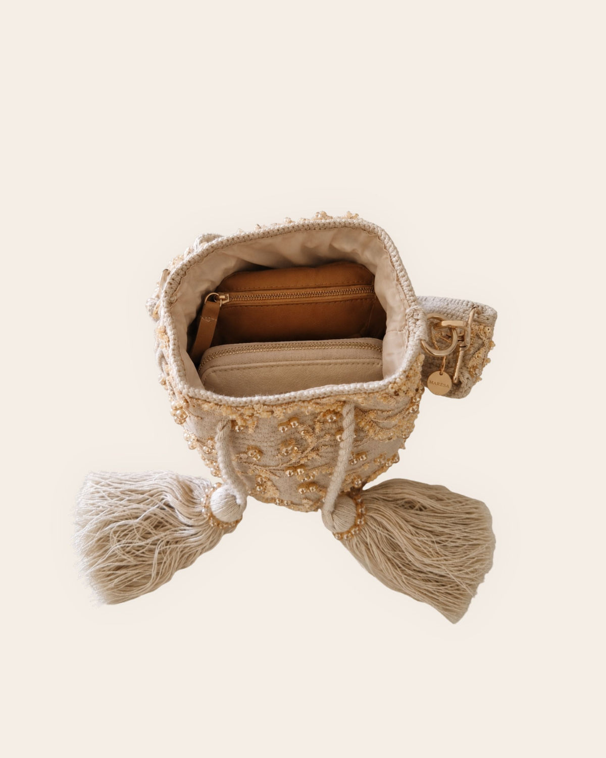 Open beige Maresa occasion bag showing lined interior and space for everyday essentials. 