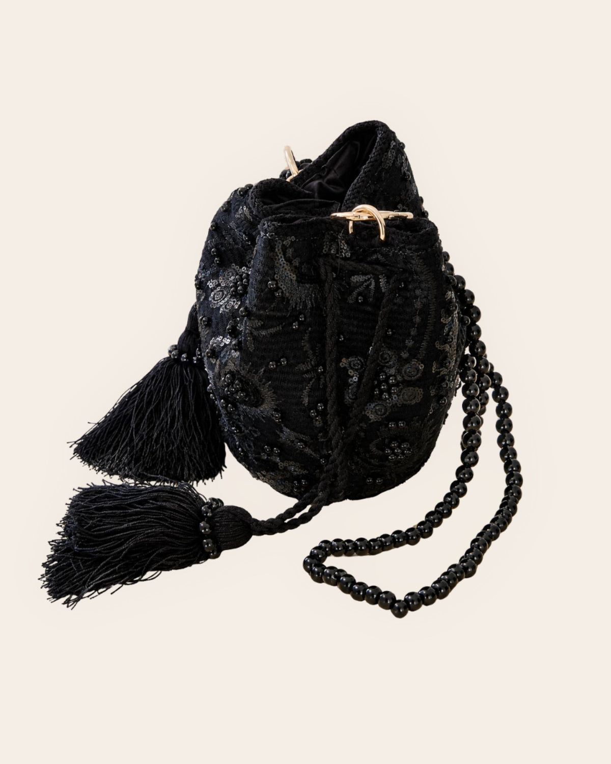 Side view of the Midnight Noir handmade occasion bag showing embroidered embellishments, tassels and detachable black beaded strap 