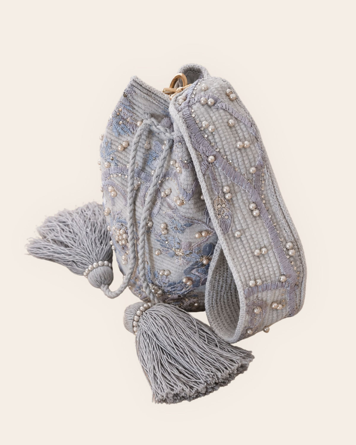 Side view of pearl grey botanical embellished occasion bag with detachable strap and tassels 